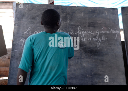 Un ancien enfant-soldat écrit le français sur un tableau de surveillance au Centre de transit et d'orientation pour les anciens enfants-soldats exploités par le CAJED, une ONG congolaise soutenue par l'UNICEF qui travaille avec des enfants et des jeunes défavorisés dans la ville de Goma. Province du Nord-Kivu RD Congo Afrique Banque D'Images