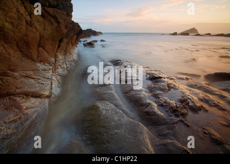 En se précipitant sur les vagues rochers de l'estran à Wembury Bay Devon UK Banque D'Images