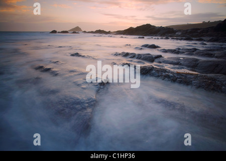 En se précipitant sur les vagues rochers de l'estran à Wembury Bay Devon UK Banque D'Images