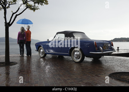 Senior couple vintage car et parapluie au quai, Italie Banque D'Images