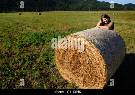 Fille de 11 ans et une balles de foin dans un pré, Gorski kotar, Croatie Banque D'Images