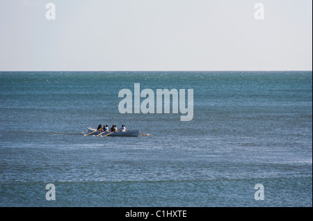 Un concert de Cornouailles étant ramé en mer près des côtes Banque D'Images