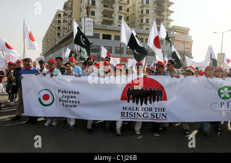 Les participants tiennent des drapeaux et bannières passent par une route pendant une marche pour exprimer la solidarité avec les victimes du séisme Banque D'Images