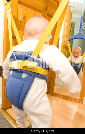 Heureux Bébé Garçon sautant à propos de Looping - en se regardant dans le miroir reflète de l'arrière Banque D'Images