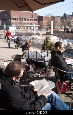 Les gens assis à l'extérieur d'un café offrant le soleil d'hiver à Aker Brygge, Oslo, Norvège. Photo:Jeff Gilbert Banque D'Images