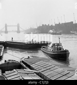 Londres, années 1950. Photographie par J Allan Paiement d'une péniche sur la Tamise, avec le Tower Bridge, au loin. Banque D'Images