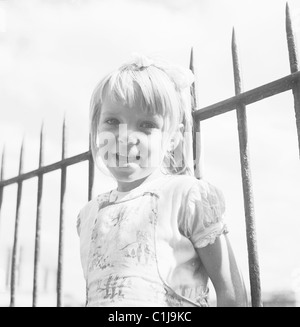 Années 1950, historique, été et une jeune fille anglaise debout contre des balustrades en fer à pointes, Londres, Angleterre, Royaume-Uni. Banque D'Images