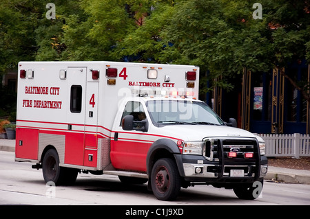 Une ambulance est envoyée en service récemment à Baltimore. En roulant le long d'une rue bordée d'arbres. Des médecins à travailler. Banque D'Images