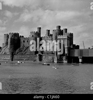 Années 1950, historique, l'ancien château de Conwy, au nord du pays de Galles construit par Édouard Ier, et sur la droite le pont ferroviaire tubulaire en fer forgé, ouvert en 1849. Banque D'Images