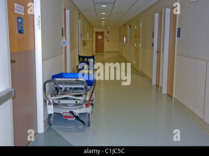 Cette scène médicale dispose d'un gurney et fauteuil roulant dans un cadre médical couloir. Banque D'Images