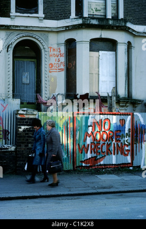 Femmes marchant passé barricadé maison mitoyenne occupés par des squatters dans Villa Road South London UK 1977 KATHY DEWITT Banque D'Images