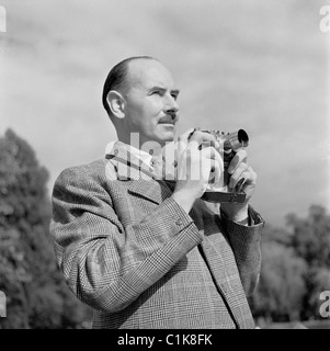 années 1950. Londres, le photographe anglais, J Allan Cash, FRPS, FIBP, avec son appareil photo. Toujours bien habillé, il a été l'un des premiers pionniers de Leica. Banque D'Images