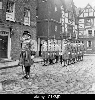 Années 1950, le directeur en chef de la Tour de Londres mène un défilé de yeoman ou gardiens de la Garde royale anglaise, Tower Green, Londres, Angleterre. Banque D'Images