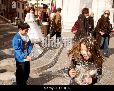 Enfants jouant avec des confettis pendant le carnaval de Venise, Italie Banque D'Images