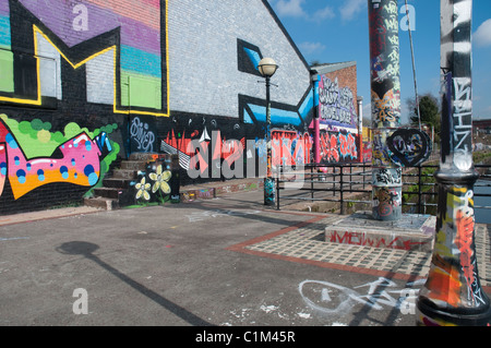 Des murs couverts de graffitis et du mobilier urbain sur les rives de la rivière Irwell, Salford. Banque D'Images