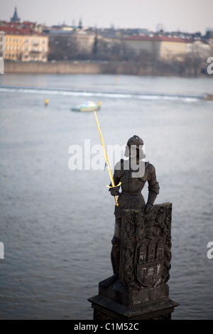 Statue sur le pont Charles (Karlov) à Prague avec le city scape derrière Banque D'Images