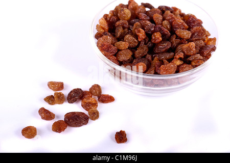 Fermer la vue d'un tas de raisins secs sur un bol isolé sur un fond blanc. Banque D'Images