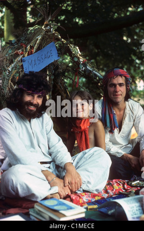 Hippies hommes hippie homme barbe et enfant assis avec un stand de massage à Barsham Fair à Beccles Suffolk Angleterre 70s 1970s 1974 KATHY DEWITT Banque D'Images