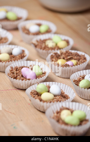 Cupcakes nids de Pâques fait avec du blé filamenté, sirop, chocolat et sucre au chocolat enrobés de mini-oeufs. Banque D'Images