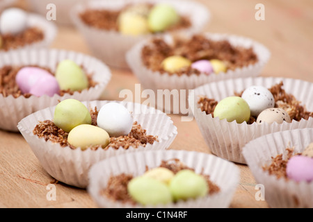 Cupcakes nids de Pâques fait avec du blé filamenté, sirop, chocolat et sucre au chocolat enrobés de mini-oeufs. Banque D'Images