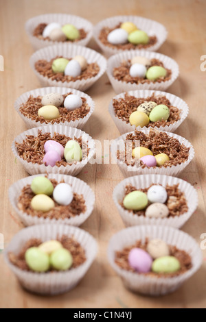 Cupcakes nids de Pâques fait avec du blé filamenté, sirop, chocolat et sucre au chocolat enrobés de mini-oeufs. Banque D'Images