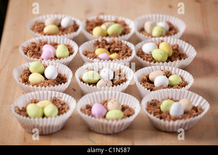 Cupcakes nids de Pâques fait avec du blé filamenté, sirop, chocolat et sucre au chocolat enrobés de mini-oeufs. Banque D'Images