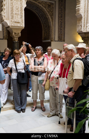 Groupe touristique / tour partie / moyen age / âgés de touristes à l'extérieur de la Cour. Alcazar de Séville / Séville. L'Espagne. Banque D'Images