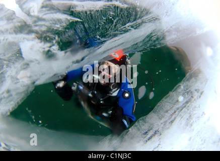 Le plongeur a l'air à travers la glace, dans le lac Baïkal, en Sibérie, la Russie, l'île Olkhon. Banque D'Images