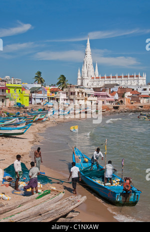 Les pêcheurs de Kanyakumari Beach waterfront la préparation des filets avec Notre Dame de rançon en arrière-plan. Banque D'Images