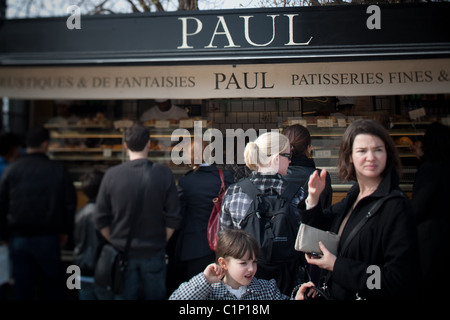 Les touristes affamés attendent en ligne à Patisserie Paul à l'extérieur de l'Hôtel du Louvre à Paris France Banque D'Images