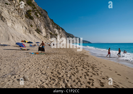 Les gens sur une plage, piscine et bains de soleil Banque D'Images