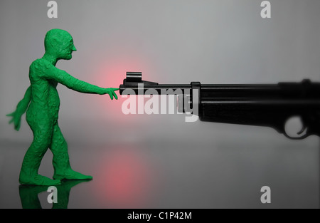 figurine d'argile à modélisation verte tenant le doigt sur le fût de pointue arme à feu (paix) Banque D'Images