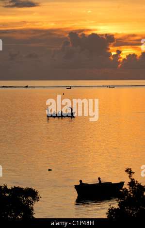 L'Île Maurice, les pêcheurs à bord de petites embarcations sur la côte sud près de Baie du Cap au coucher du soleil Banque D'Images