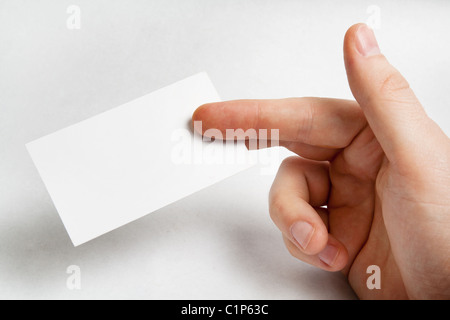 Hand holding blank business card over white Banque D'Images