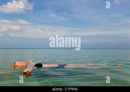 Woman floating on sea Banque D'Images