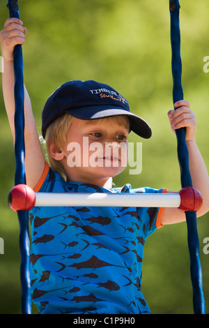 Boy climbing ladder à jeux pour enfants Banque D'Images