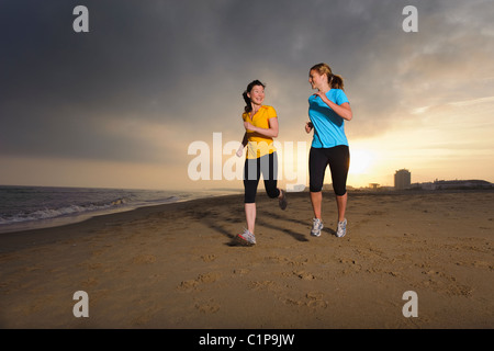 Les femmes jogging on beach Banque D'Images