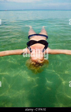 Woman floating on sea Banque D'Images