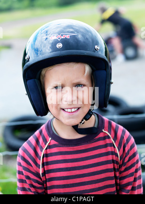 Portrait de jeune garçon portant un casque à piste de karting Banque D'Images