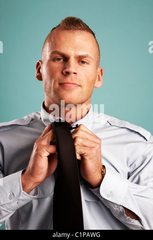 Security guard adjusting tie, portrait Banque D'Images