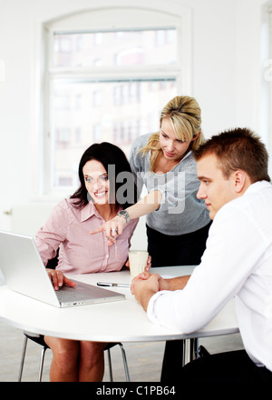 Business people looking at laptop in office Banque D'Images