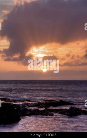 Les rayons de lumière émanant du soleil couchant, des vagues briser, Maui Banque D'Images