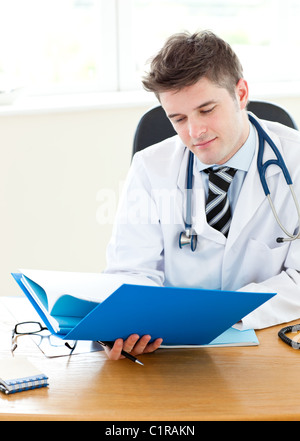Beau jeune médecin détenant un dossier Banque D'Images