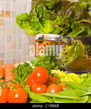 Fruits et légumes frais reflète dans un boîtier en acier inoxydable collander Banque D'Images