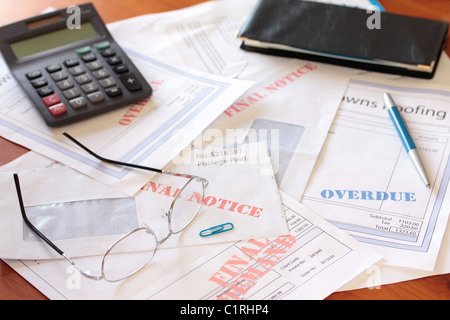 "Factures impayées en souffrance sur la table avec la calculatrice et vérifier livre ' Banque D'Images