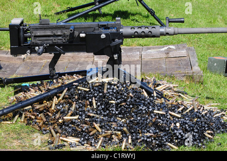 Une mitrailleuse Browning de calibre .50 avec une pile de dossiers et liens. Banque D'Images