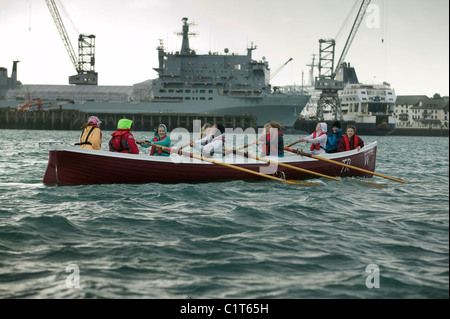 Un projet pilote en cours de concert avec la rame dans le port de Falmouth navire auxiliaire de la flotte à l'arrière-plan Banque D'Images