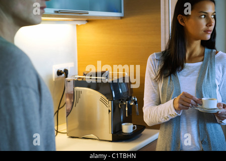 Woman enjoying tasse de café dans la cuisine Banque D'Images