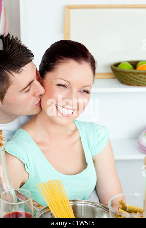 Couple joyeux la préparation de spaghetti dans la cuisine et vins drinkng Banque D'Images