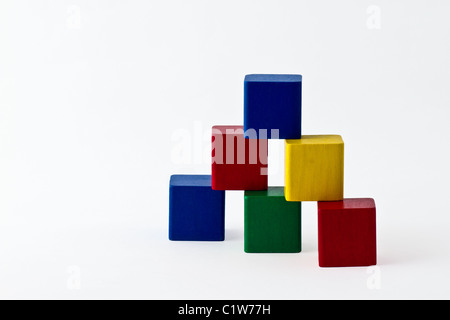 Blocs de construction colorés disposés sous la forme d'une pyramide. isolé sur blanc. Banque D'Images